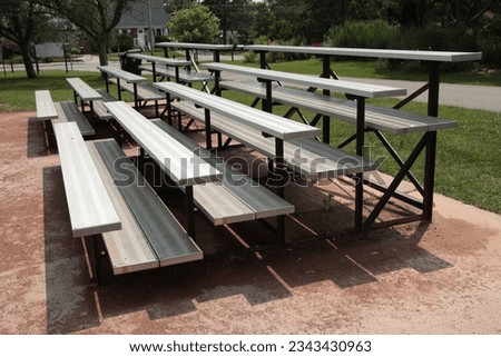 two small empty outdoor silver sports bleacher sets, shot from side angle