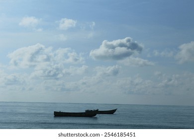 Two small fishing boats anchored on a calm sea under a clear blue sky with scattered fluffy white clouds. A serene and minimalist seascape evoking tranquility and freedom. - Powered by Shutterstock