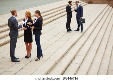 Two Small Groups Of Business People Interacting Outside