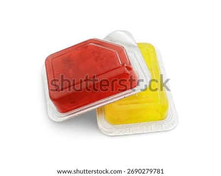 Two small plastic containers with red strawberry and yellow pineapple jam isolated on white.