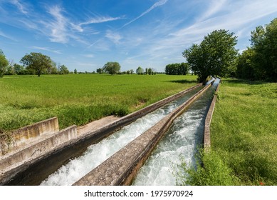 Two small reinforced concrete irrigation canals in the Padan Plain or Po valley (Pianura Padana, italian). Mantua province, Italy, southern Europe.