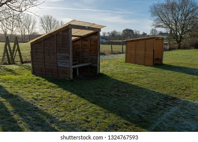 Two Small Rustic Football Dugouts In A Field, The Home Dugout In The Foreground