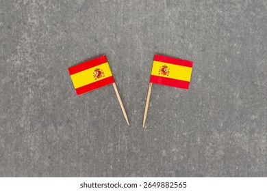 Two Small Spain Flags on Grey Background