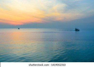 Two Small Transport Fishing Boat Running Wide Ocean Sea In Morning Fresh Orange And Blue Twilight Sky Or Golden Hour With Calm Sea Waves At Southern Chomphon Province,Thailand