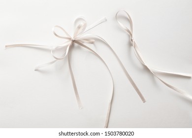 Two Small White Bow Or Ribbon On A White Background