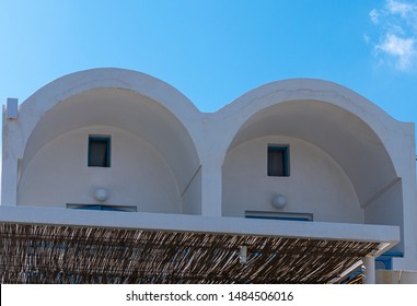 Two small windows peek out bether traditional arched roofs of this Fira holiday home