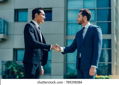 Two Smiling Adult Business Men Shaking Hands