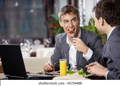 Two smiling business men eat at restaurant - Powered by Shutterstock