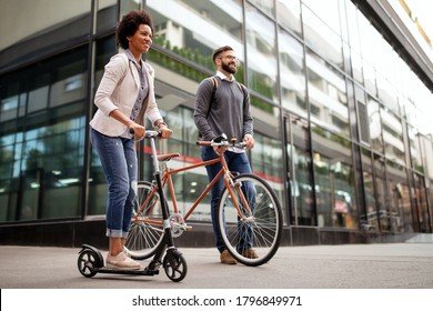 Two Smiling Business People Driving Electric Scooter, Bicycle Going To Work.