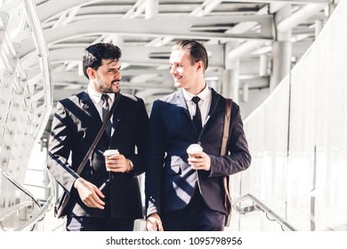 Two Smiling Businessmen Talking And Walking In The City