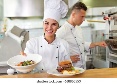 Two Smiling Chefs In Kitchen
