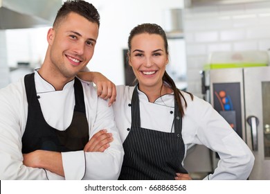 Two Smiling Chefs In Kitchen
