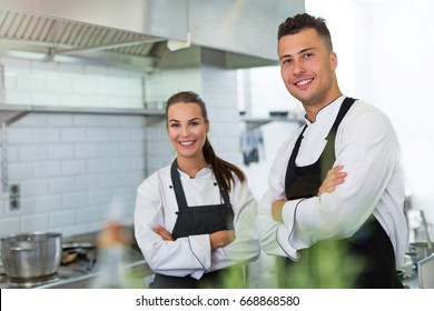 Two Smiling Chefs In Kitchen
