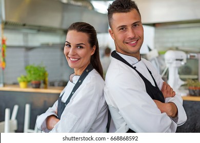 Two Smiling Chefs In Kitchen
