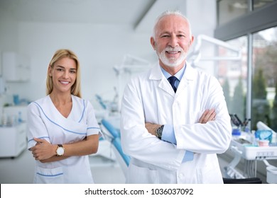 Two Smiling Dentists In A Dental Office, Professional Dental Team