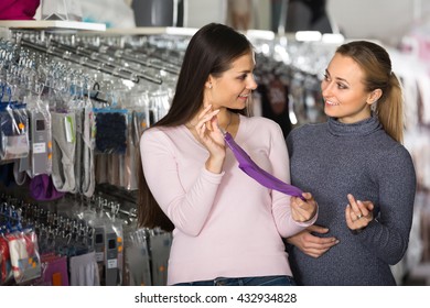 Two Smiling Female Friends Choosing Cotton Panties In Underwear Store
