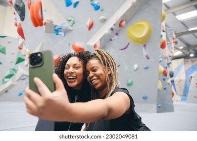 Two Smiling Female Friends Posing For Selfie By Climbing Wall At Indoor Activity Centre - Powered by Shutterstock