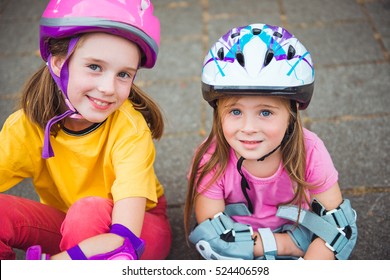 Two Smiling Kids In Protective Helmet And Sportswear For Cycling