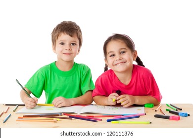 Two smiling little kids at the table draw with crayons, isolated on white - Powered by Shutterstock