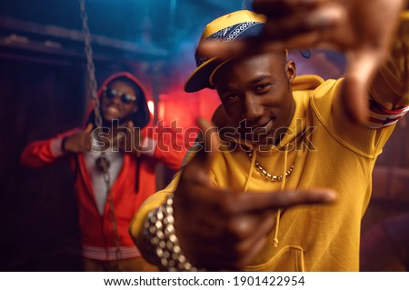 Two smiling rappers, breakdancing in studio
