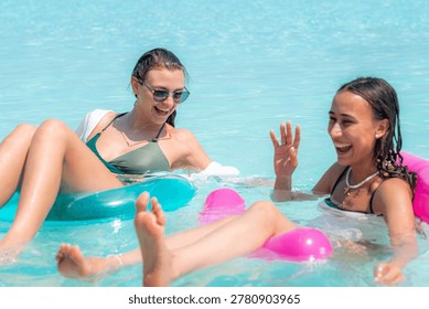 Two smiling vacationers float on rafts in turquoise waters of the Maldives, enjoying a sunny escape, relaxation, tranquility, idyllic getaway, summer bliss.