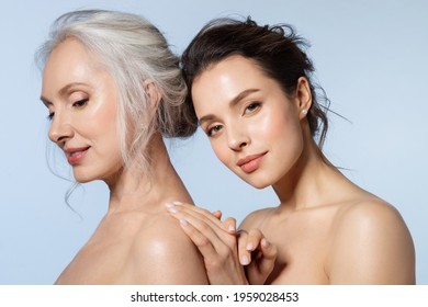 Two smiling women of different ages looking at different side holding hand closeup portrait. Young girl cuddling snuggling mom from back. Warmth in relation between parent and adult kid