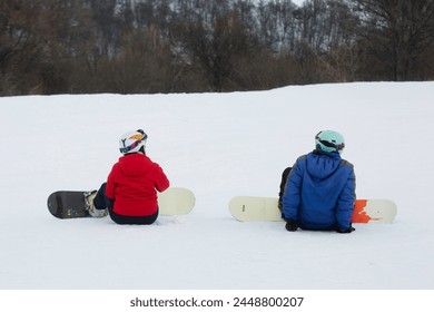Two Snowboarders Sitting On A Snowy Slope - Powered by Shutterstock