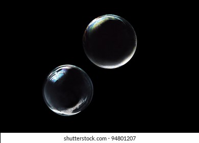 two soap bubbles on black background