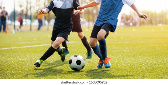 Two Soccer Players Running And Kicking A Soccer Ball. Legs Of Two Young Football Players On A Match. European Football Youth Player Legs In Action