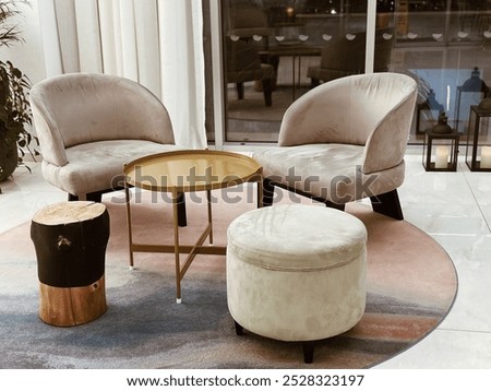 two soft chairs and table in the hotel lobby with a carpet