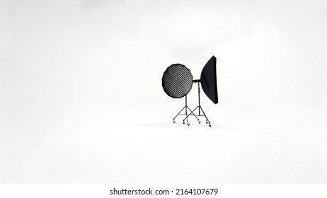 Two softbox studio lights stand against a white cyclorama