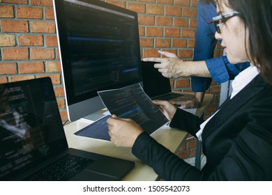 Two software developers are analyzing together about the code written into the program on the computer.