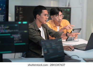 Two software developers collaborate in a modern office while reviewing computer code and building advanced artificial intelligence solutions