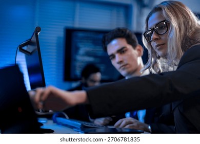 Two software developers smile with satisfaction during a pair programming session, as one points to a successfully executed block of code after solving a complex programming problem.