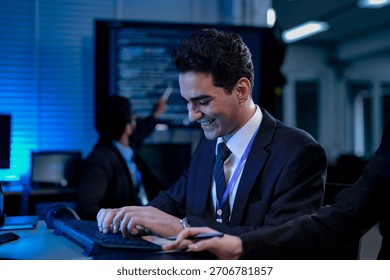Two software developers smile with satisfaction during a pair programming session, as one points to a successfully executed block of code after solving a complex programming problem.