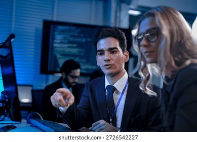 Two software developers smile with satisfaction during a pair programming session, as one points to a successfully executed block of code after solving a complex programming problem.