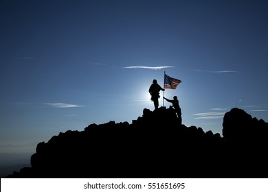 Two Soldiers Raise The American Flag On Top Of The Mountain