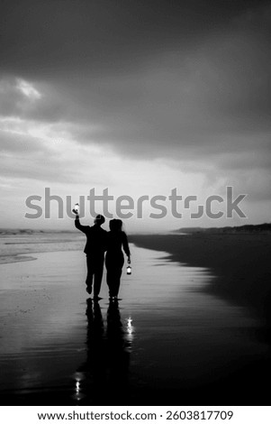 Two souls, one path, guided by the gentle glow of a lantern. Walking hand in hand, embracing the magic of the night by the shore