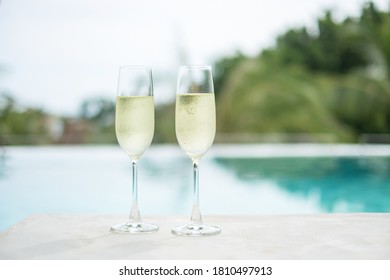 Two Sparkling Champagne Glasses Or Prosecco Near Swimming Pool. Summer Travel, Vacation, Holiday And Weekend Concept