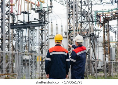 Two specialist electrical substation engineers inspect modern high-voltage equipment. Energy. Industry