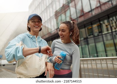 Two sportive happy female friends walking city after morning running - Powered by Shutterstock