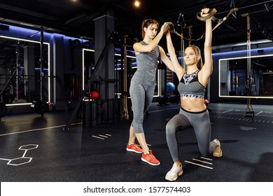 Two sportive women in sportswear exercising with rubber bands in stretch