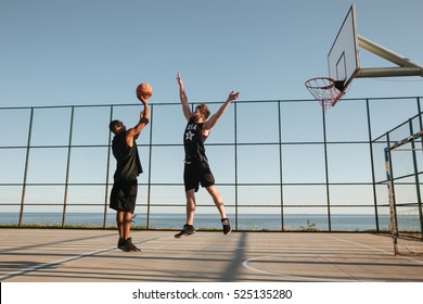 Two Sportsmen Playing Basketball At The Playgroud