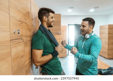 Two sportsmen standing in locker room while having a conversation. Guys being busy in engaging talk about soccer game match they've watched. - Powered by Shutterstock