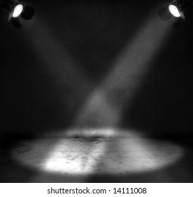 Two spotlights shining on a grungy floor in a room