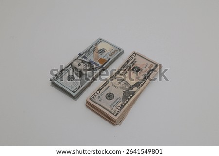 Two stack of fifty and hundreds us dollars bills on isolated white background on distance