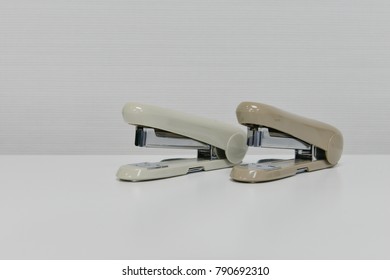 Two stapler is on the white table