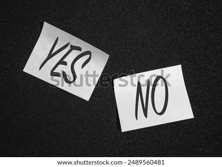 Two  sticky notes on a black background with yes and no.