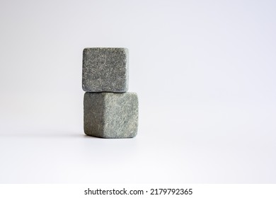 Two stone cubes one above the other. Whiskey stones on a white background.
