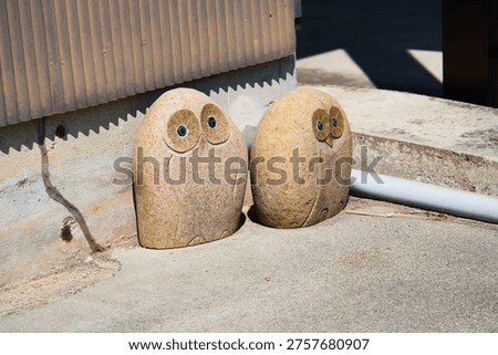 Two stone owl statues sitting side by side